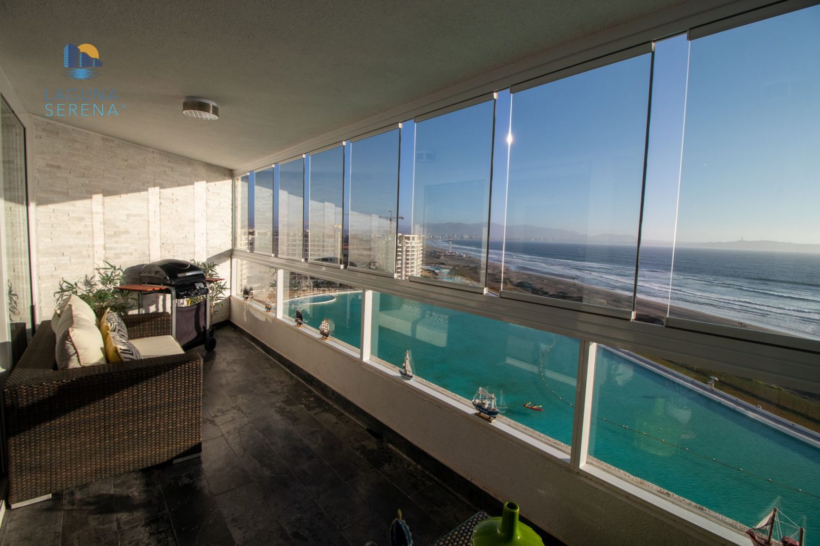 Terraza con vista al mar y cortinas de cristal